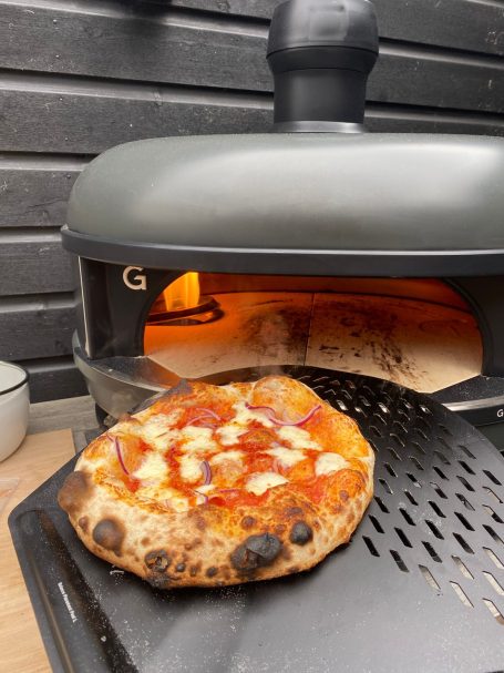Versgebakken pizza met tomatensaus en kaas, net uit de oven.